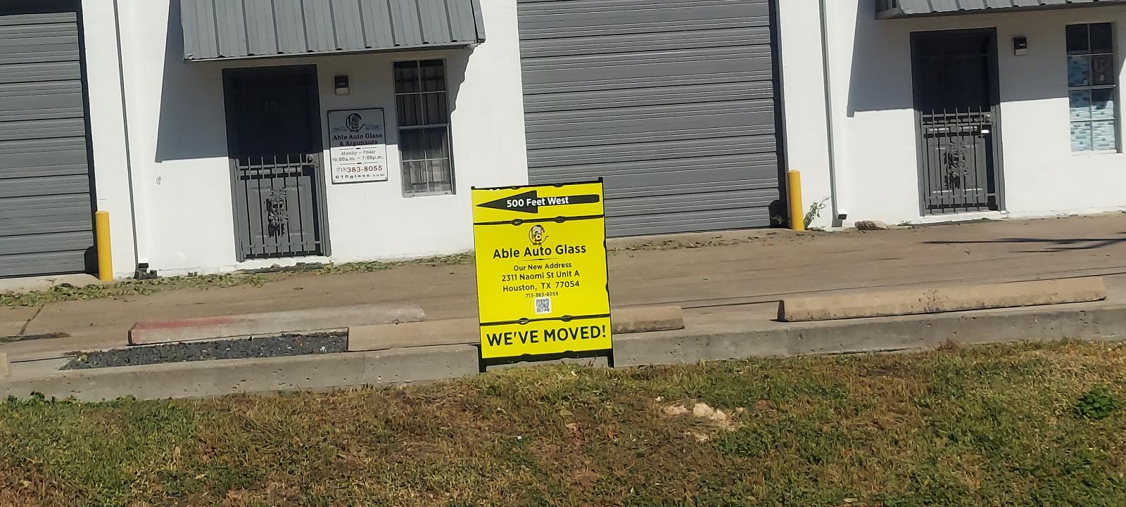 Able Auto Glass relocation sign with yellow background, bold text reading WE'VE MOVED.